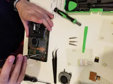 Laptop opened on the bench with tools laid out